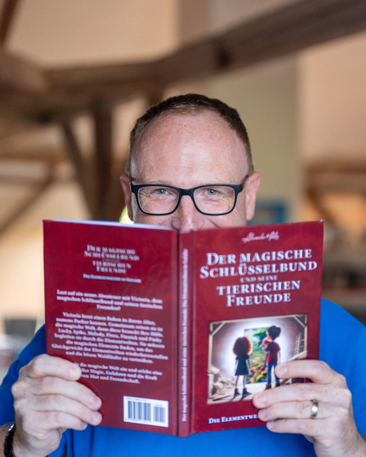 Kinderbuchautor Alexander Miklós mit einem Buch seiner Reihe